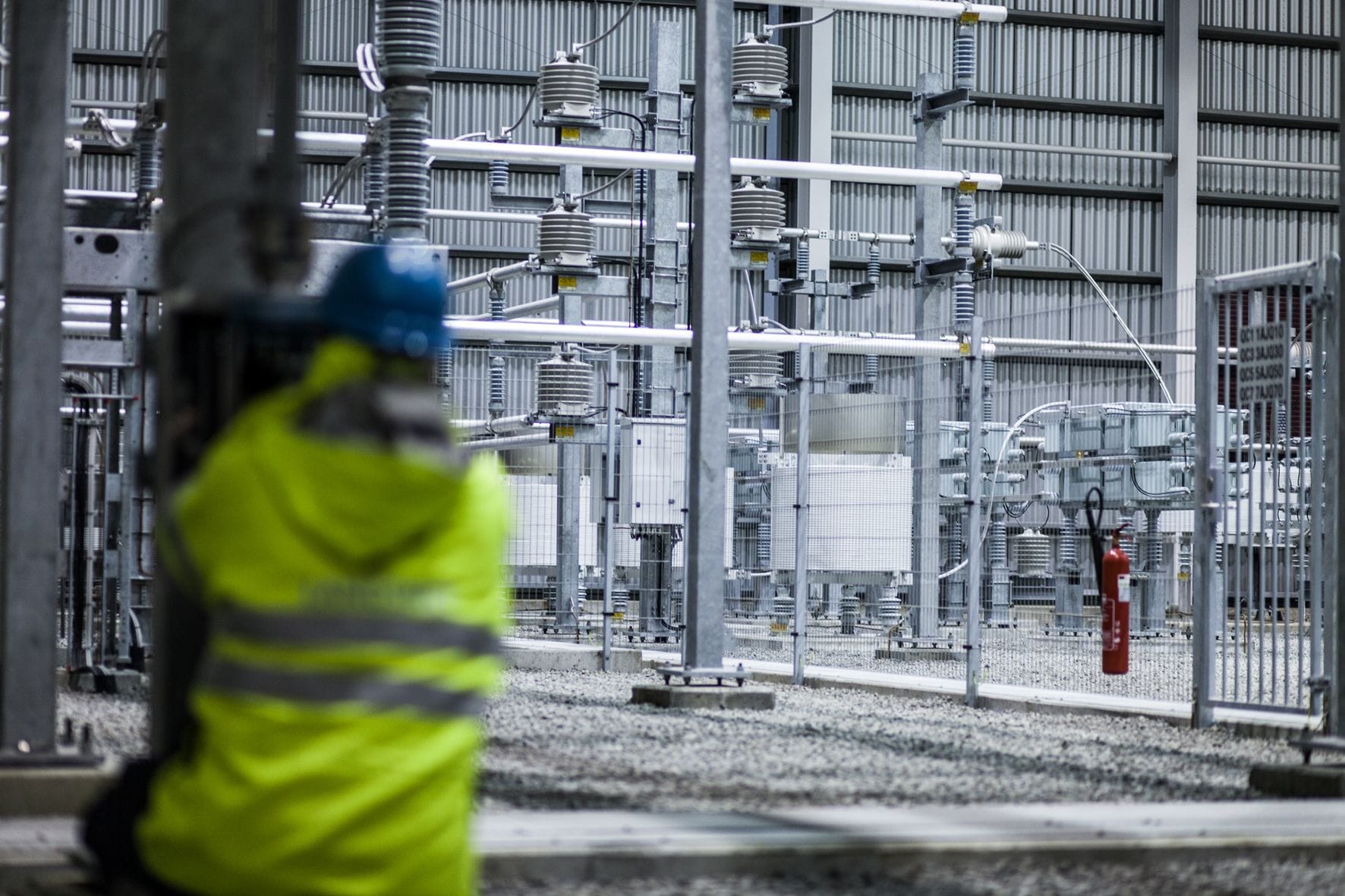 Maður í vinnugalla í tengivirki.